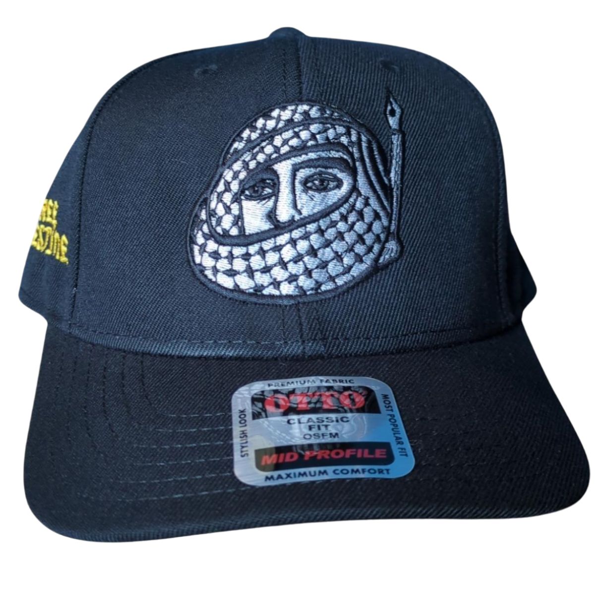 A bold statement in thread and fabric—this hat turns symbolism into streetwear, honoring the intertwined power of resistance and expression. Black snapback hat with an embroidered face in a keffiyeh and a pen-shaped flag.