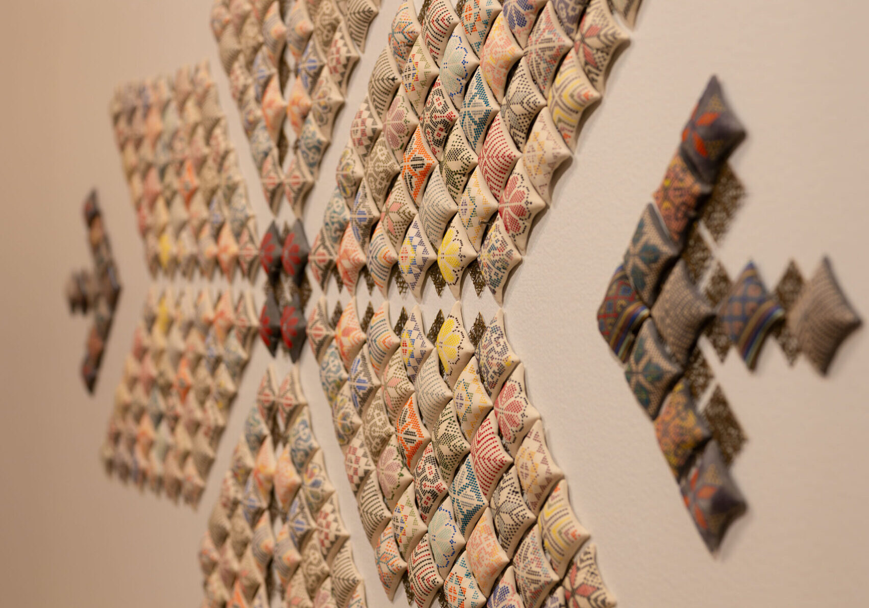 Tatreez-inspired ceramic installation by Palestinian artist Pam Totah featuring miniature embroidered pillows